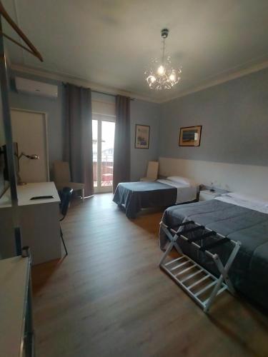 una camera da letto con due letti e un lampadario di Siculè B&B a Catania