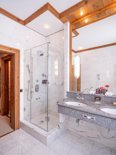 a bathroom with two sinks and a shower at Kulm Hotel St. Moritz in St. Moritz