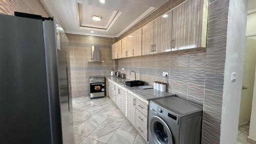 a kitchen with a washer and dryer in it at Prime Residence Apartments in Sukuta
