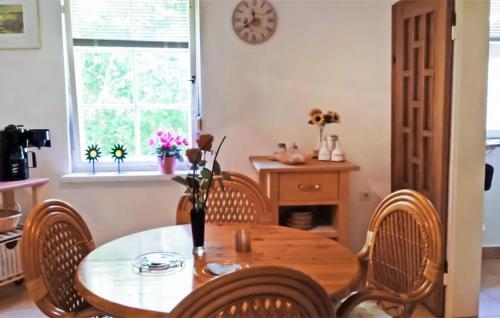 ein Esszimmer mit einem Tisch, Stühlen und einer Uhr in der Unterkunft 1 Bedroom Lovely Home In Mahlow in Mahlow