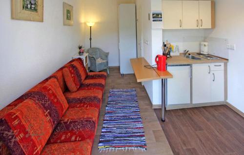 a living room with a red couch and a kitchen at Cozy Apartment In Wusterhusen With Kitchen in Wusterhusen