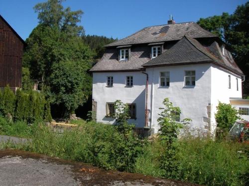 una vieja casa blanca con techo gris en Tolles Ferienhaus in Presseck mit Grill und Garten en Presseck