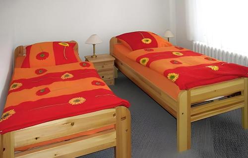 2 Einzelbetten in einem Zimmer mit roten Decken in der Unterkunft Beautiful Apartment In Bad Doberan With Kitchen in Bad Doberan