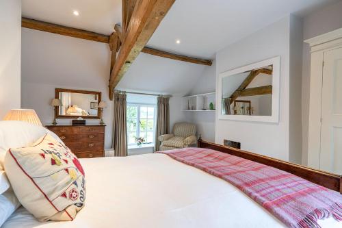 a bedroom with a large white bed and a mirror at Middle Farm House in Shepton Mallet