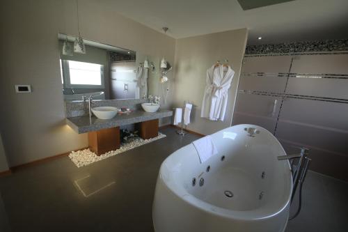 a bathroom with a large tub and two sinks at Orucoglu Oreko Hotel in Manisa