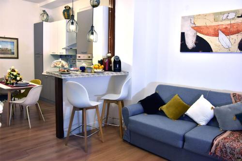 sala de estar con sofá azul y cocina en Gloden House Apartments, en Taormina