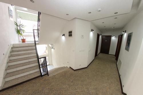 an empty hallway with stairs and a potted plant at Hotel Hayat in Sarajevo