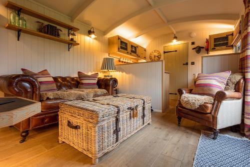 a living room with a couch and a table and chairs at Holly Lodge Boutique B&B in Thursford