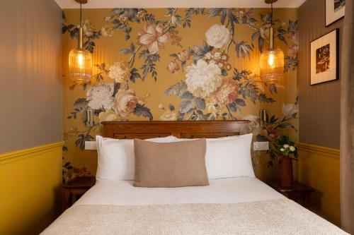 a bedroom with a bed with a floral wallpaper at Welcome Hotel in Paris