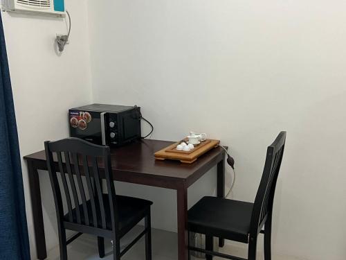 einen kleinen Tisch mit 2 Stühlen und eine Mikrowelle in der Unterkunft Dreamy Sunset Bay in Manila