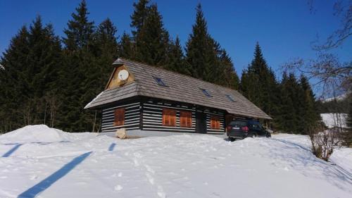 une cabane en rondins avec une voiture garée dans la neige dans l'établissement Nettes Ferienhaus in Telgárt, à Telgárt