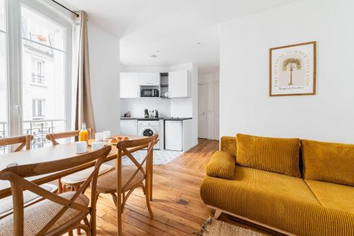 un salon avec une table et un canapé jaune dans l'établissement Jolie 2 pièces proche métro - Paris 19 - 4p - FLAT-GUEST, à Paris