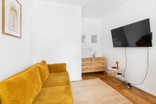 un salon avec un canapé et une télévision à écran plat dans l'établissement Jolie 2 pièces proche métro - Paris 19 - 4p - FLAT-GUEST, à Paris