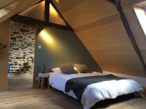 a bedroom with a large bed in a attic at La Maison de Mano in Plouër-sur-Rance
