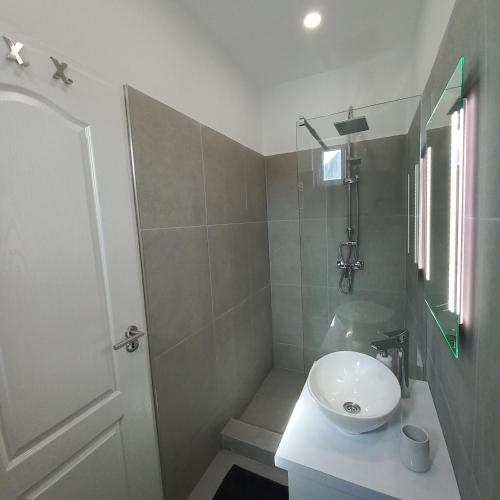 a bathroom with a white sink and a shower at Stílus Apartman in Vásárosnamény