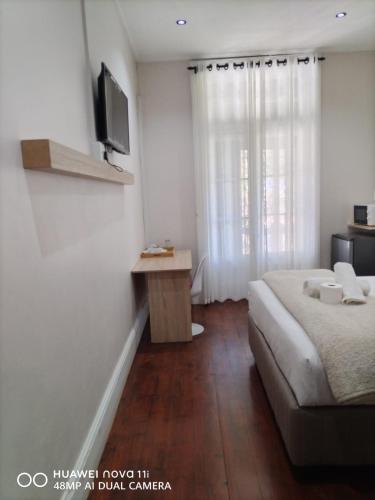 a bedroom with a bed and a television on a wall at HEBA GUEST LODGE in Uitenhage