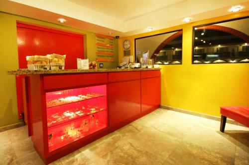 a kitchen with red and yellow walls and a counter at Hotel Boulevard Mexicali in Mexicali