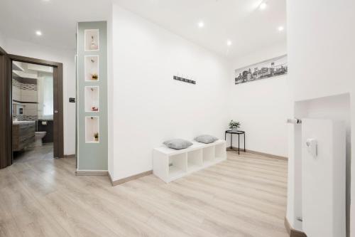 salon z białymi ścianami i drewnianą podłogą w obiekcie Due passi dal mare w Genui