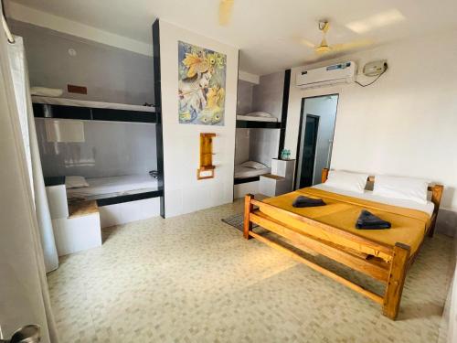 a bedroom with a bed and two bunk beds at The Meraki Beach Resort in Gokarna