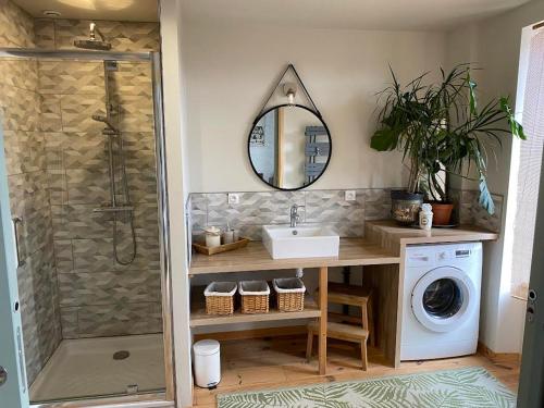 a bathroom with a sink and a washing machine at La Maison de Mano in Plouër-sur-Rance