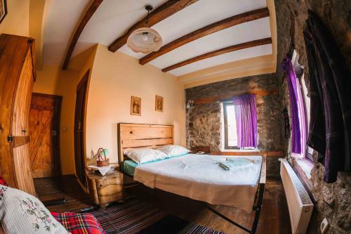 Rancho i Vancho na Kata في Omorani: غرفة نوم بسرير كبير في غرفة حجرية