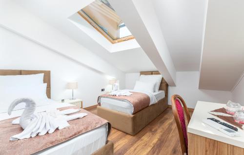 een slaapkamer met 2 bedden en een tafel met een zwaan erop bij Hotel Dua Residence in Poreč