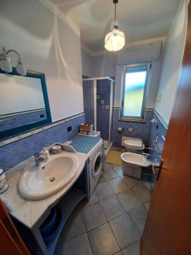 a bathroom with a sink and a washing machine at Residence Mare Blu in Capo dʼOrlando