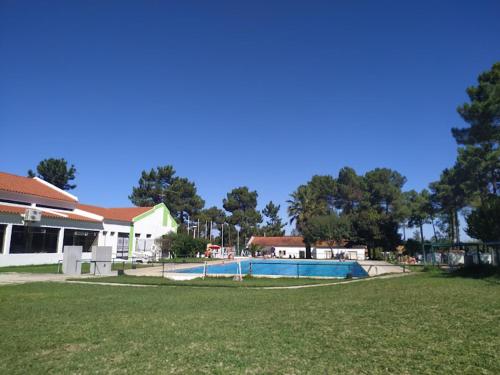 a swimming pool in a yard next to a house at Kampaoh Sesimbra in Sesimbra