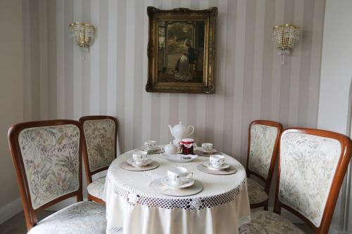 ein Esszimmer mit Tisch und Stühlen und einem Teeservice in der Unterkunft Apartament pałacowy in Świebodzin
