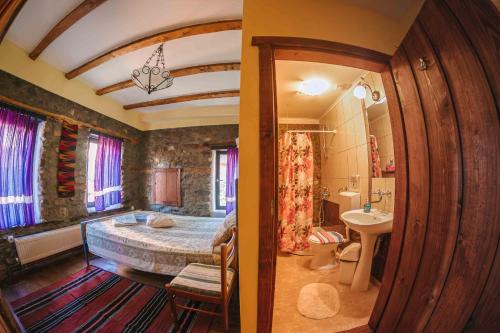 a bedroom with a large bed and a bathroom at Rancho i Vancho na Kata in Omorani