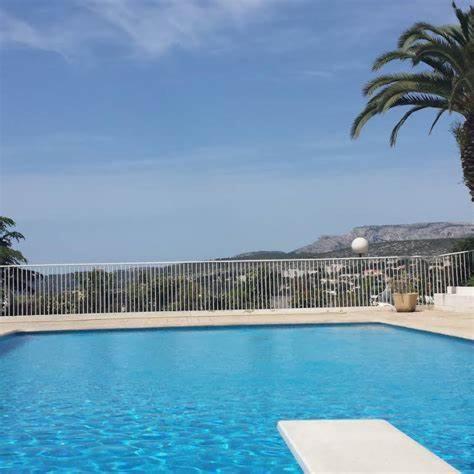 une grande piscine bleue avec une clôture dans l'établissement STUDIO LA PINTA CASSIS, à Cassis
