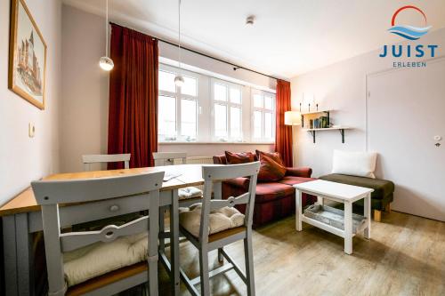 a living room with a table and a couch at Haus Inselresidenz Strandburg 301 - Wohnung 101 in Juist