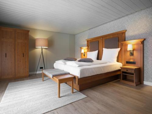 a bedroom with a large bed with a wooden headboard at Luisenhof by Bütgenbacher-Hof in Butgenbach