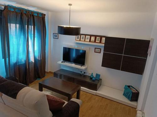 a living room with a couch and a tv at Apartamento El Toboso in Alcalá de Henares