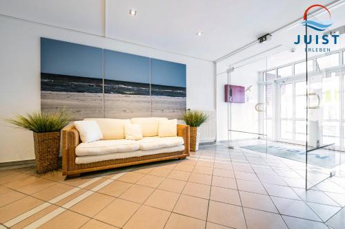 a living room with a couch on a tiled floor at Haus Inselresidenz Strandburg 302 - Wohnung 102 in Juist