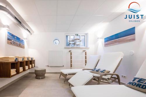a waiting room with white chairs and a table at Haus Inselresidenz Strandburg 302 - Wohnung 102 in Juist
