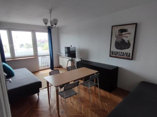 a living room with a table and a couch at Warszawa Apartament z Widokiem in Warsaw