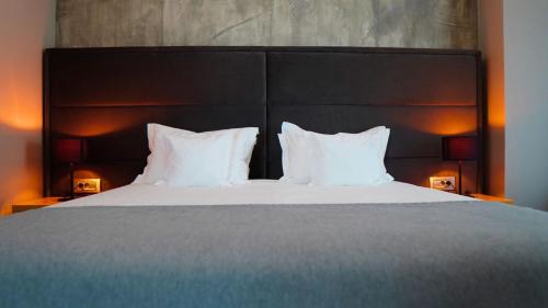 a bedroom with a large bed with white pillows at Aniroc Signature Hotel in Arad