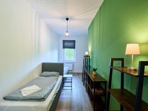 a bedroom with a bed and a green wall at Sali-Homes Boarding Haus Monteur-Wohnungen Balkon Vollküche Autobahnähe in Markranstädt