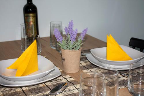 a wooden table with plates with yellow napkins on them at Kolymvari Hills in Chania Town