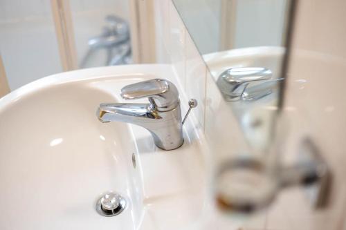 a white bathroom sink with a chrome faucet at Stylish 1-Bed Flat in Bristol in Bristol