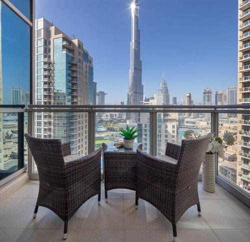 einen Balkon mit einem Tisch und Stühlen sowie Stadtblick in der Unterkunft Ramble Stay Hostel Burj Khalifa view in Dubai