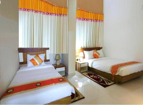 1 dormitorio con 2 camas y ventana en NAAS Serviced Apartments, en Dhaka