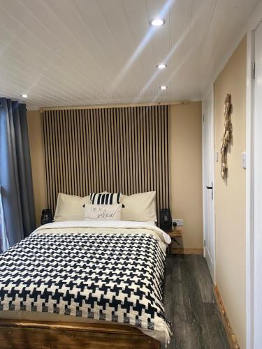 a bedroom with a large bed with a striped wall at Devon River Glamping Pods in Alloa