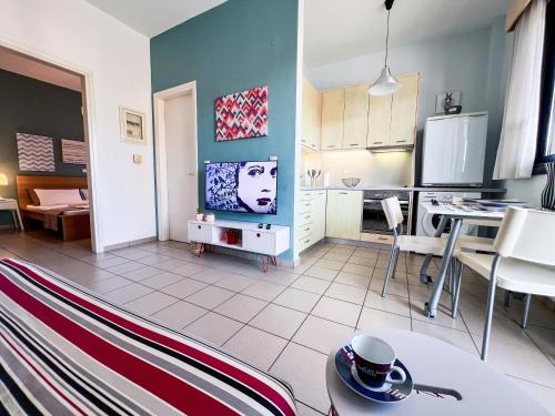 a kitchen and living room with a tv and a table at CityZEN View - Retro Nest in Argostoli