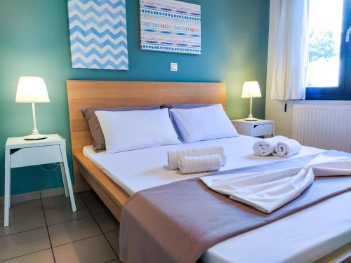 a bedroom with a large bed with towels on it at CityZEN View - Retro Nest in Argostoli