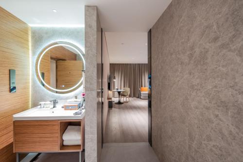 a bathroom with a sink and a mirror at UrCove by HYATT Shanghai Jing'An in Shanghai