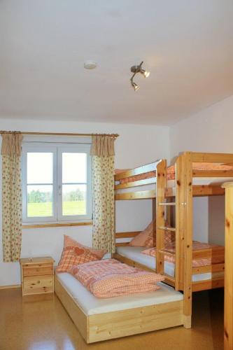 a bedroom with two bunk beds and a window at Granerhof Ferien in Peißenberg