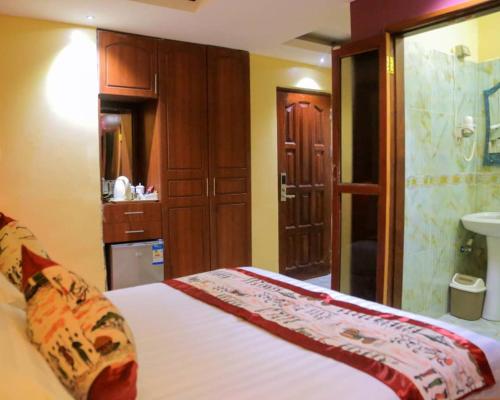 sypialnia z łóżkiem oraz łazienka z umywalką w obiekcie Perla Hotel w mieście Kampala