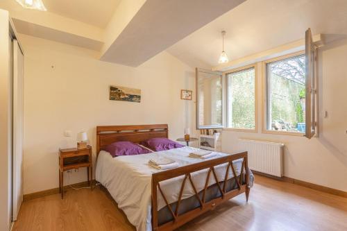 a bedroom with a bed and a window at La Maison Télémaque in Marennes